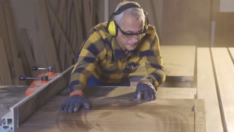 Carpenter-working-with-saw-in-workshop.
